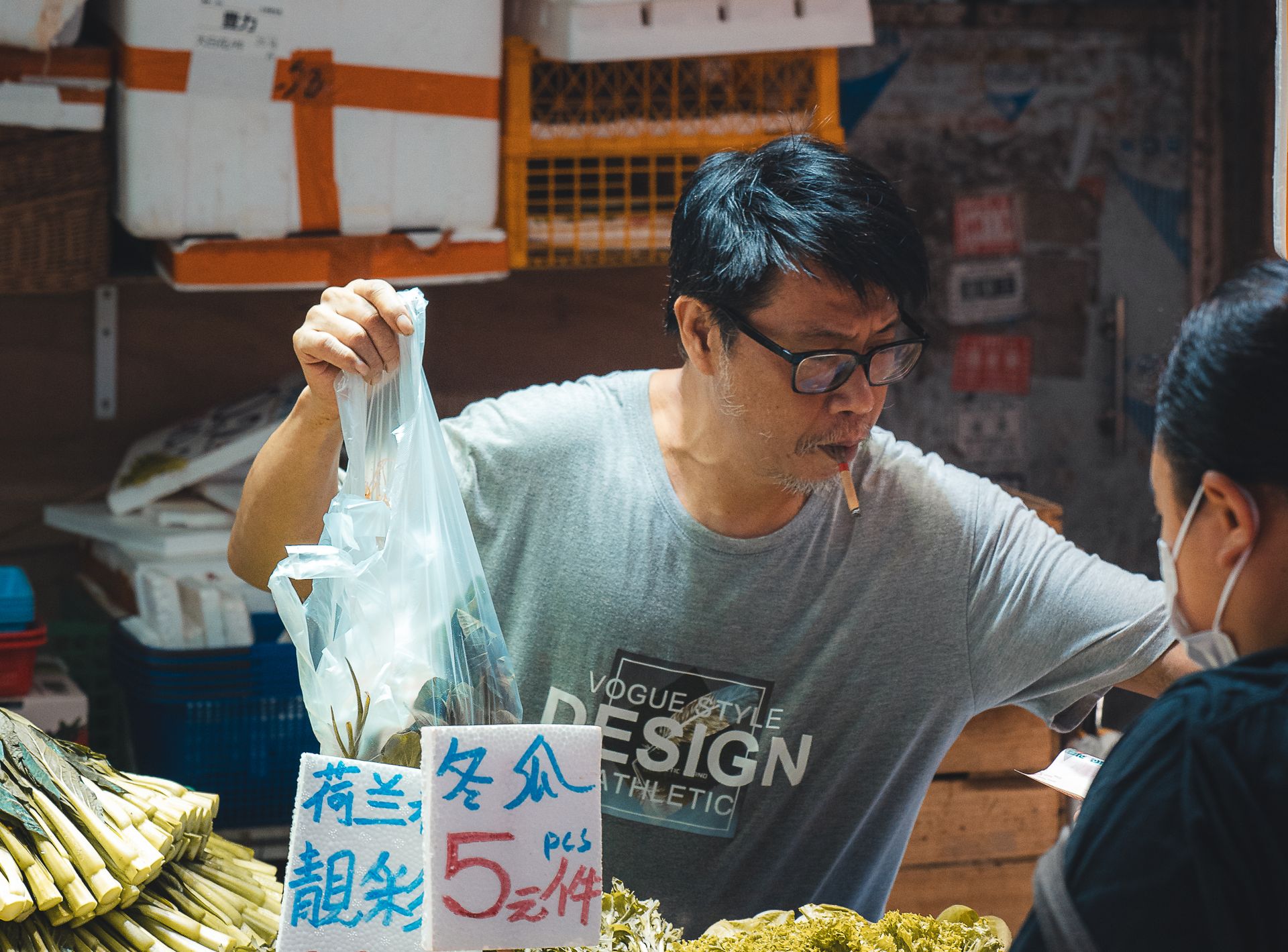 Un boucher au travail dans un marché humide de Hong Kong, marchandises fraîches suspendues