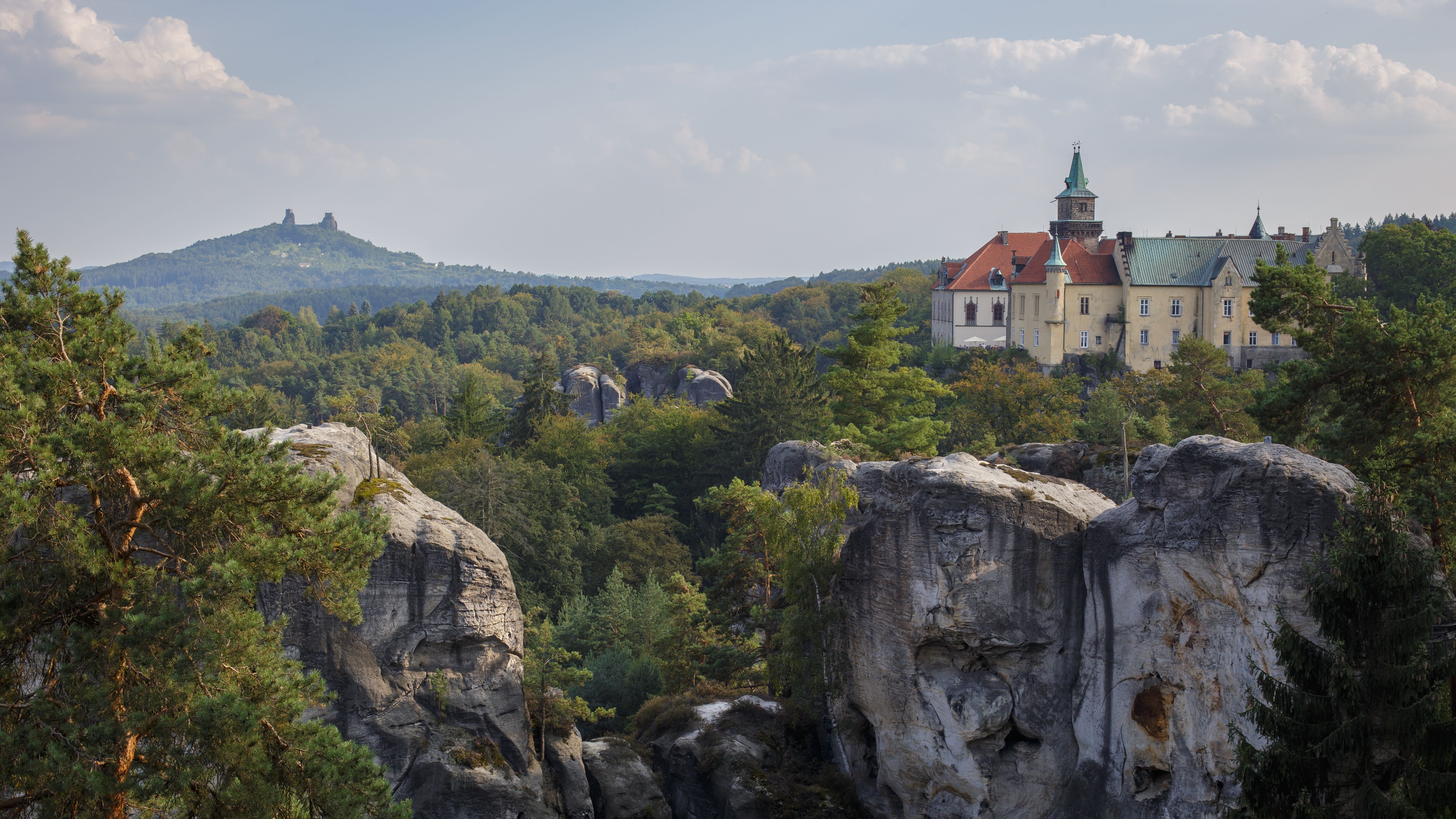 Un château à tour ronde domine une petite ville aux toits rouges au bord d'un méandre.