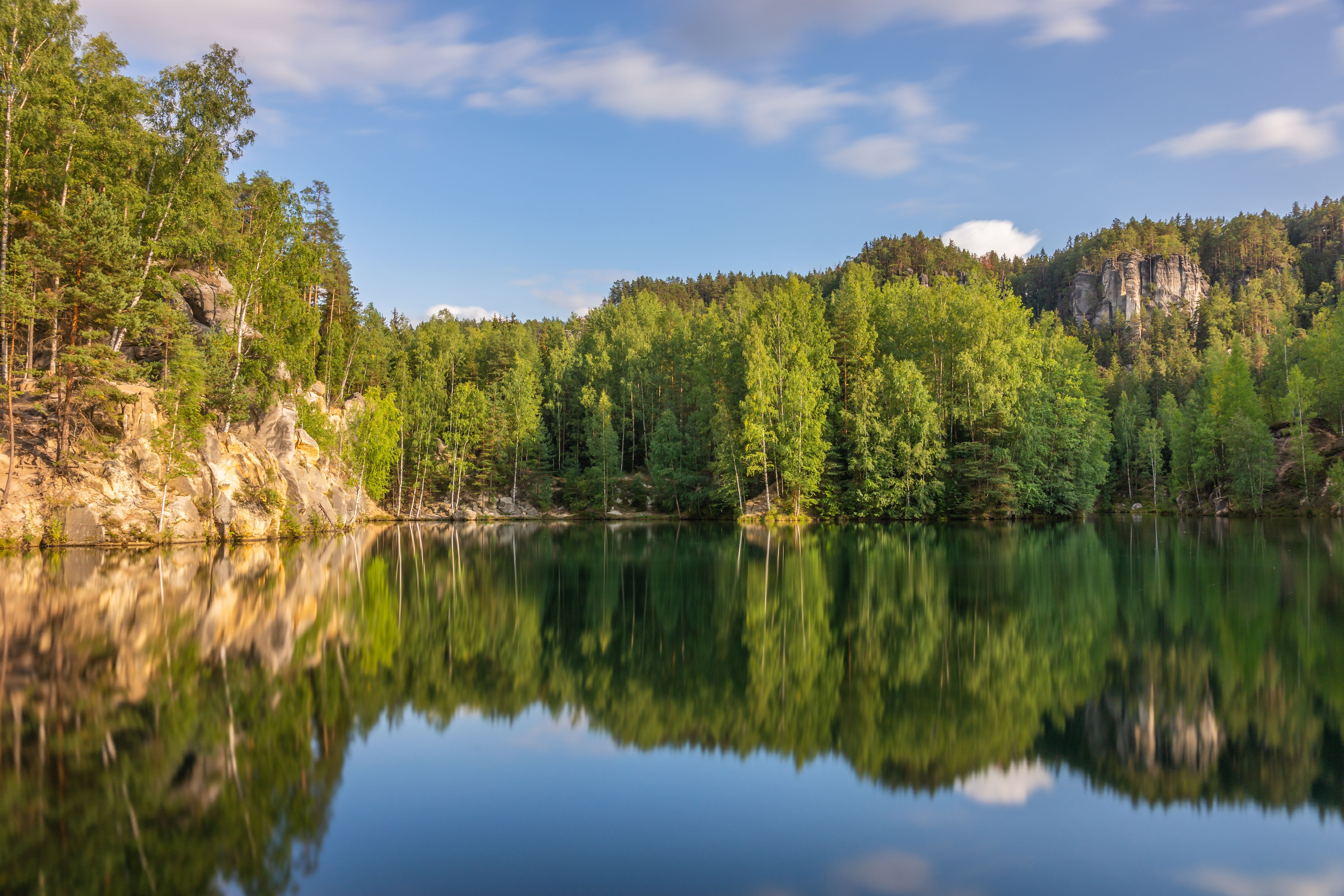 Des tours de grès émergent de la forêt, avec des champs vallonnés jusqu'à l'horizon.