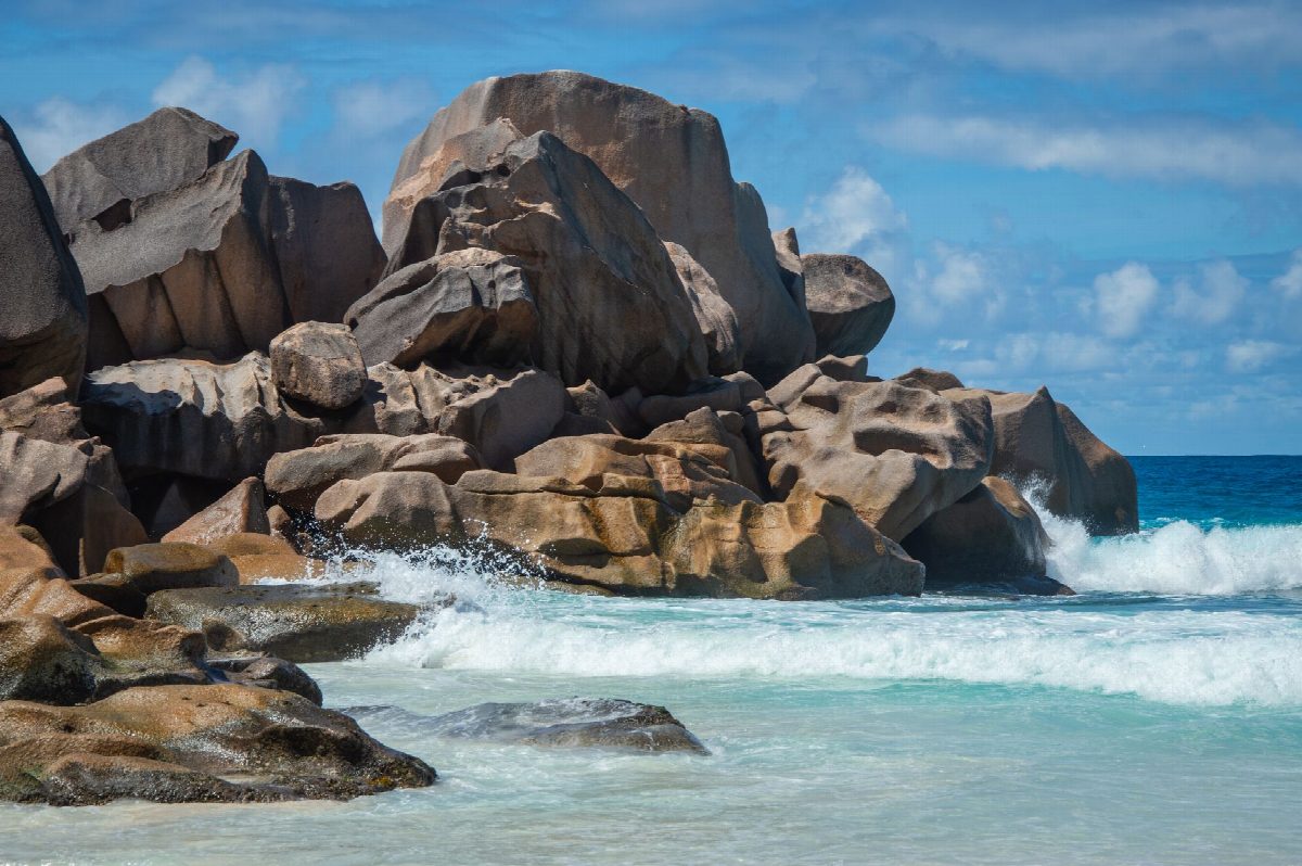 Granietrotsen boven een schaduwrijk strand op Mahé